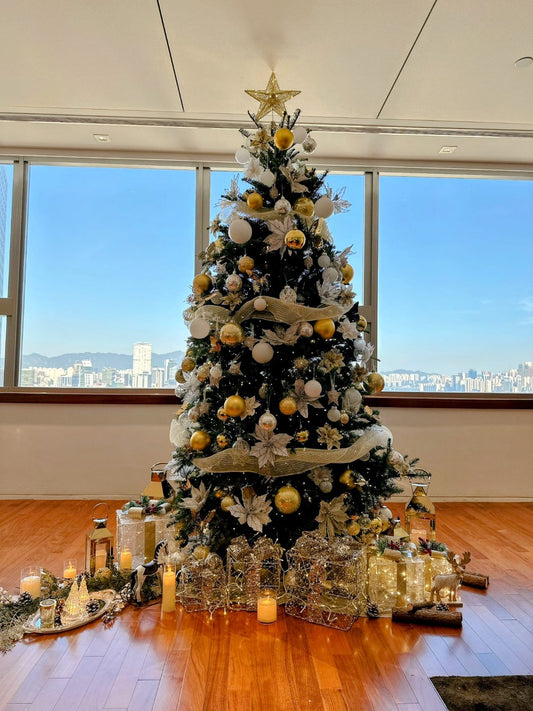 Christmas tree styled with gold and silver decorations and a city backdrop